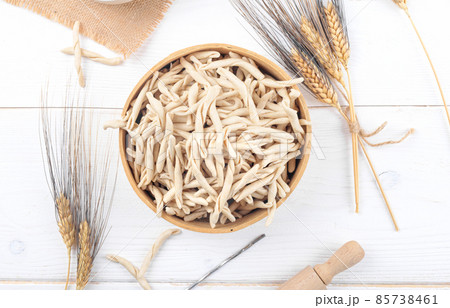 Whole grain wheat raw apulian pasta called Pizzarieddi or maccaruni in a sieve on white wooden table Whole grain wheat raw apulian pasta called Pizzarieddi or maccaruni in a sieve on white wooden table 85738461