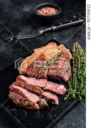 Roasted bbq Chuck Roll beef steaks with herbs. Black background. Top view 85740612