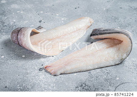 Two raw haddock fish fillets on kitchen table. Gray background. Top view 85741224