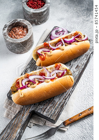 Vegetarian hot dog with with toppings and meatless sausage. White background. Top view Vegetarian hot dog with with toppings and meatless sausage. White background. Top view 85741454