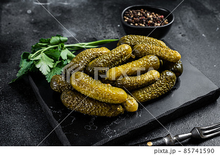 Gherkin Pickled cucumbers with garlic and spices. Black background. Top view Gherkin Pickled cucumbers with garlic and spices. Black background. Top view 85741590