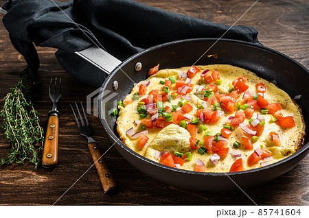 Healthy breakfast food, Stuffed egg omelet with vegetables in a skelet. Wooden background. Top view Healthy breakfast food, Stuffed egg omelet with vegetables in a skelet. Wooden background. Top view 85741604
