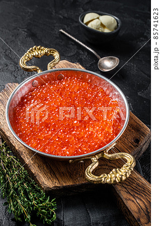 Red caviar in skillet on wooden board. Balck background. Top view 85741623