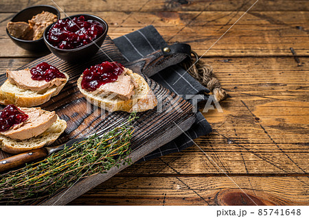 French cuisine Foie gras toasts, goose liver pate and lingonberry marmalade. wooden background. Top view. Copy space 85741648