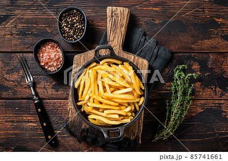 Skilet full of Potato french fries with salt. Wooden background. Top view 85741661