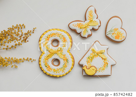Easter gingerbread cookies and mimosa flowers on white background. top view copy space. Hello Spring concept Easter gingerbread cookies and mimosa flowers on white background. top view copy space. Hello Spring concept 85742482