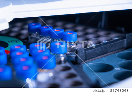 Close up vials with blue caps in the rack of auto sample for LC MS analysis. Research experiment of vaccine. Clinical analysis to detect diseases. 85743043