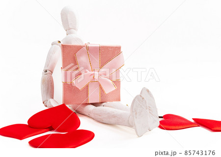 Wooden man figure with Valentines Day gift box, white background. Copy space 85743176