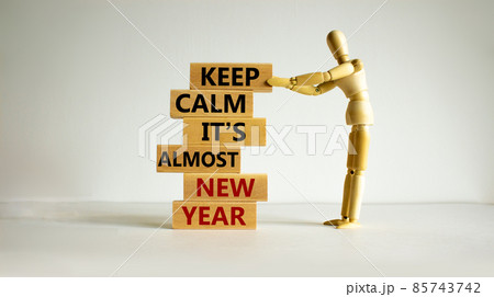 Concept of new year. Wooden blocks with words 'keep calm it is almost new year'. Wooden model of human. Beautiful white background, copy space. Business and new year concept. 85743742