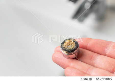Dirty clogged bathroom faucet aerator in hand above the mixer in the sink. Tap filter. 85744065