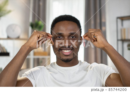 Smiling guy holds in hands pink transparent patches near his eyes 85744200