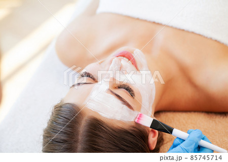 Woman getting facial care by beautician at spa salon 85745714