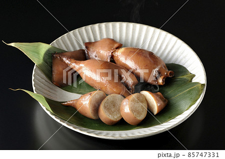 笹の葉に乗っている郷土料理の出来立てイカ飯を黒背景で撮影 85747331