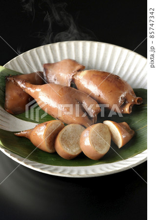 笹の葉に乗っている郷土料理の出来立てイカ飯を黒背景で撮影 85747342