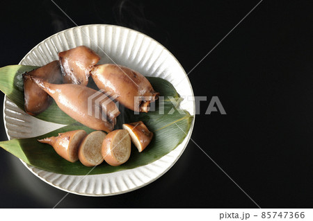 笹の葉に乗っている郷土料理の出来立てイカ飯を黒背景で俯瞰撮影 笹の葉に乗っている郷土料理の出来立てイカ飯を黒背景で俯瞰撮影 85747366
