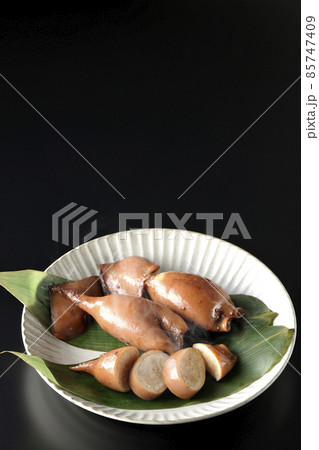 笹の葉に乗っている郷土料理の出来立てイカ飯を黒背景で撮影 85747409