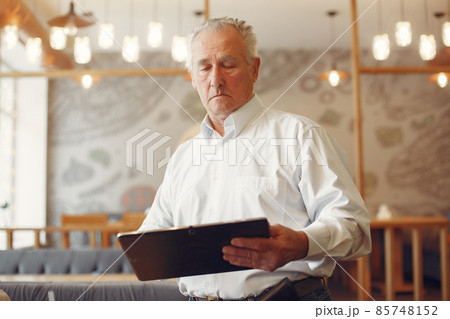 Elegant old man in a cafe using a laptop 85748152