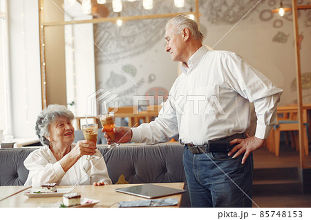 Beautiful old couple sitting in a cafe Beautiful old couple sitting in a cafe 85748153