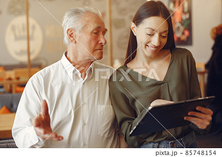 Girl teaching her grandfather how to use a tablet 85748154