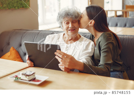 Girl teaching her grandmother how to use a tablet 85748155