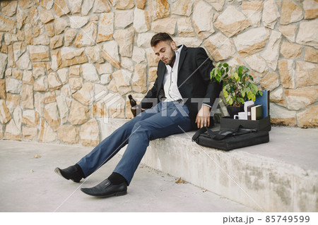 Upset fired european man getting drunk outside 85749599