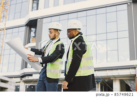 Black man and european looking at blueprint outside 85749621
