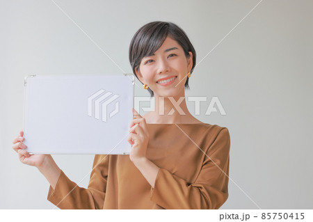 メッセージボードを顔の横に掲げる女性4 85750415