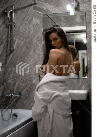 Topless woman looking in mirror 85751588