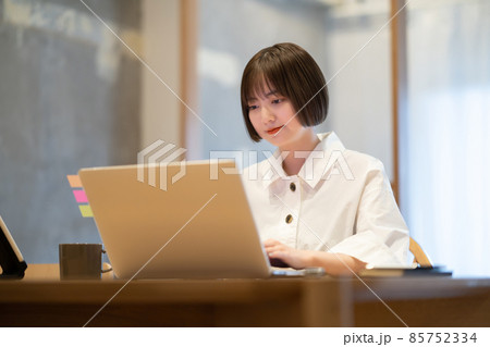 自宅の部屋でノートPCを操作する若い女性 85752334