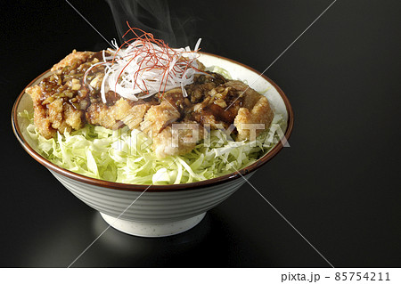白髪葱、糸唐辛子、千切りキャベツ、出来立て熱々油淋鶏丼を黒背景で撮影 白髪葱、糸唐辛子、千切りキャベツ、出来立て熱々油淋鶏丼を黒背景で撮影 85754211