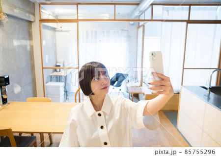 室内でスマートフォンをかざす女性 室内でスマートフォンをかざす女性 85755296