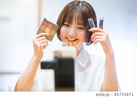 スマートフォンを使ってコスメグッズを紹介する女性 スマートフォンを使ってコスメグッズを紹介する女性 85755871