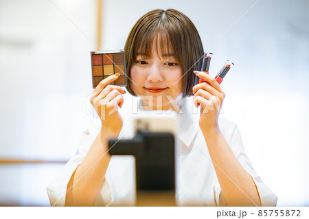 スマートフォンを使ってコスメグッズを紹介する女性 スマートフォンを使ってコスメグッズを紹介する女性 85755872