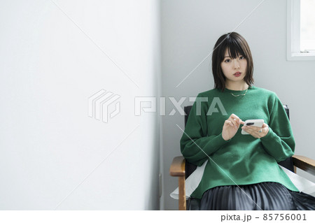 部屋でスマートフォンを使う女性 85756001