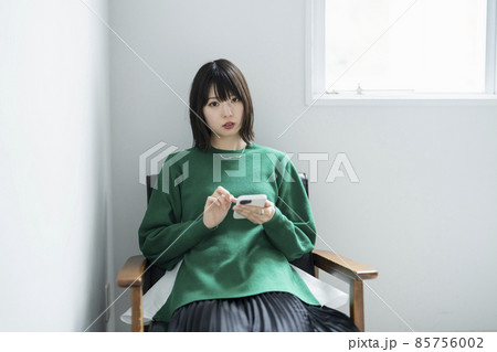 部屋でスマートフォンを使う女性 部屋でスマートフォンを使う女性 85756002