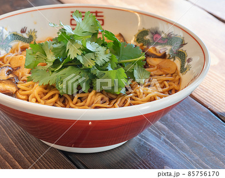 パクチーをトッピングした辛くて酸っぱいラーメン。担担麺や酸辣湯麺など。 85756170