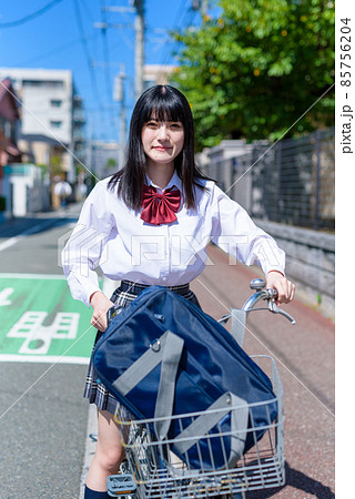 後ろから風を受け、笑顔で自転車通学する女子高校生 住宅地 市街地 カメラ目線 後ろから風を受け、笑顔で自転車通学する女子高校生 住宅地 市街地 カメラ目線 85756204