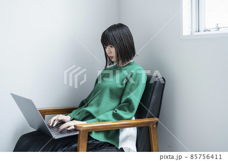 部屋でノートパソコンを使う女性 部屋でノートパソコンを使う女性 85756411