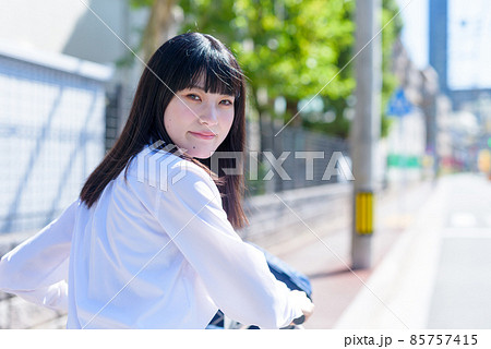 笑顔で自転車通学する女子高校生 後ろ姿振り向き 住宅地 市街地 笑顔で自転車通学する女子高校生 後ろ姿振り向き 住宅地 市街地 85757415