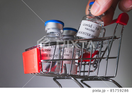 COVID-19 booster vaccine vials in shopping cart. Medicine and health care concept COVID-19 booster vaccine vials in shopping cart. Medicine and health care concept 85759286