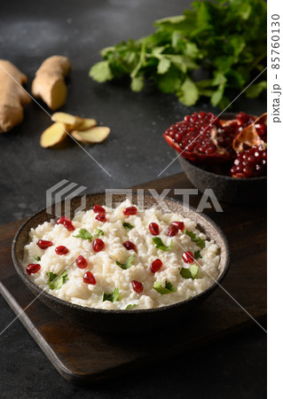 Curd Rice with pomegranate, cilantro, mustard seeds, ginger on a black background. Indian cuisine Curd Rice with pomegranate, cilantro, mustard seeds, ginger on a black background. Indian cuisine 85760130
