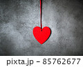 Minimalistic decoration, red heart over textured grey background 85762677