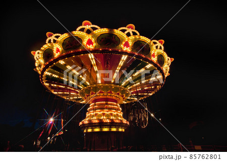 Colorful chain swing carousel in motion at amusement park at night. 85762801