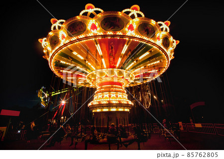 Colorful chain swing carousel in motion at amusement park at night. 85762805