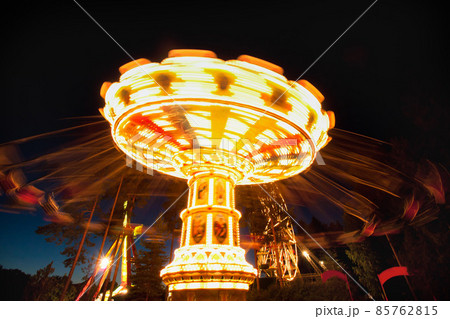 Colorful chain swing carousel in motion at amusement park at night. 85762815