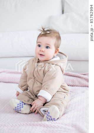 Adorable baby in warm overall sitting on the blanket 85762994