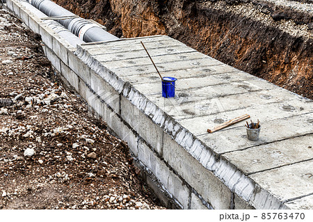Construction works on large iron pipes at a depth of excavated trench 85763470