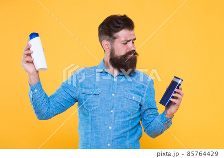 Bath cosmetics review. Man bearded hipster hold plastic Bath cosmetics review. Man bearded hipster hold plastic 85764429