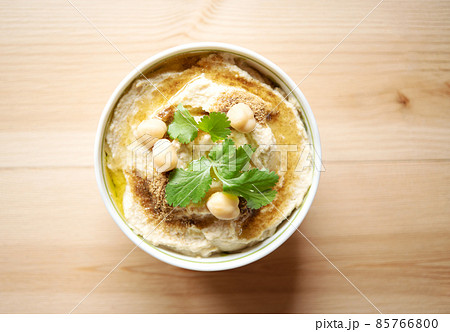 Top view of homemade hummus in ceramic bowl on woodle table. Healthy food Top view of homemade hummus in ceramic bowl on woodle table. Healthy food 85766800
