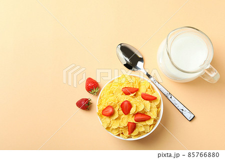 Concept of tasty breakfast with cornflakes on beige background Concept of tasty breakfast with cornflakes on beige background 85766880